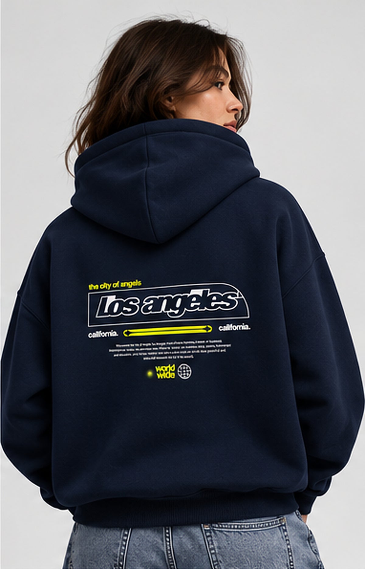 Female model wearing navy oversized Los Angeles printed hoodie back view