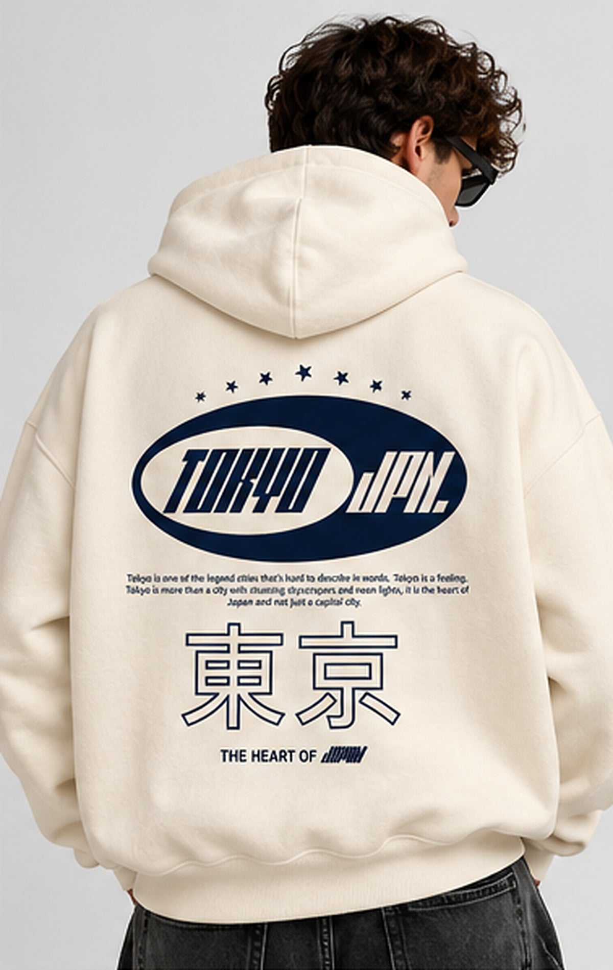 Male model showing navy Tokyo Japan graphic across cream hoodie back